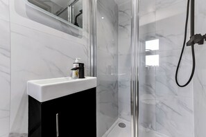 Een douche, handdoeken, zeep, toiletpapier