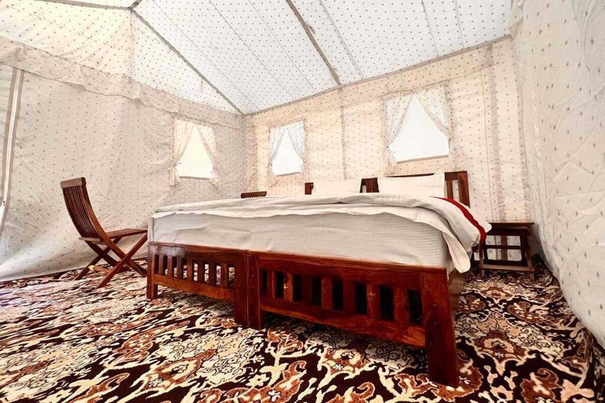 A room with a bed, a chair, and a small table.