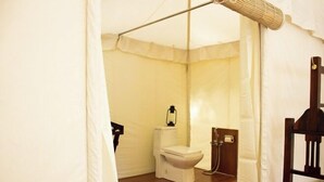 Un bagno piccolo e compatto, con il water, un lavabo e una lampada a sospensione.