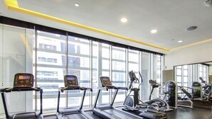 A gym with treadmills, exercise bikes, and weight machines. - LUX  The Bonnington JLT Suite 2 (Dubai)
