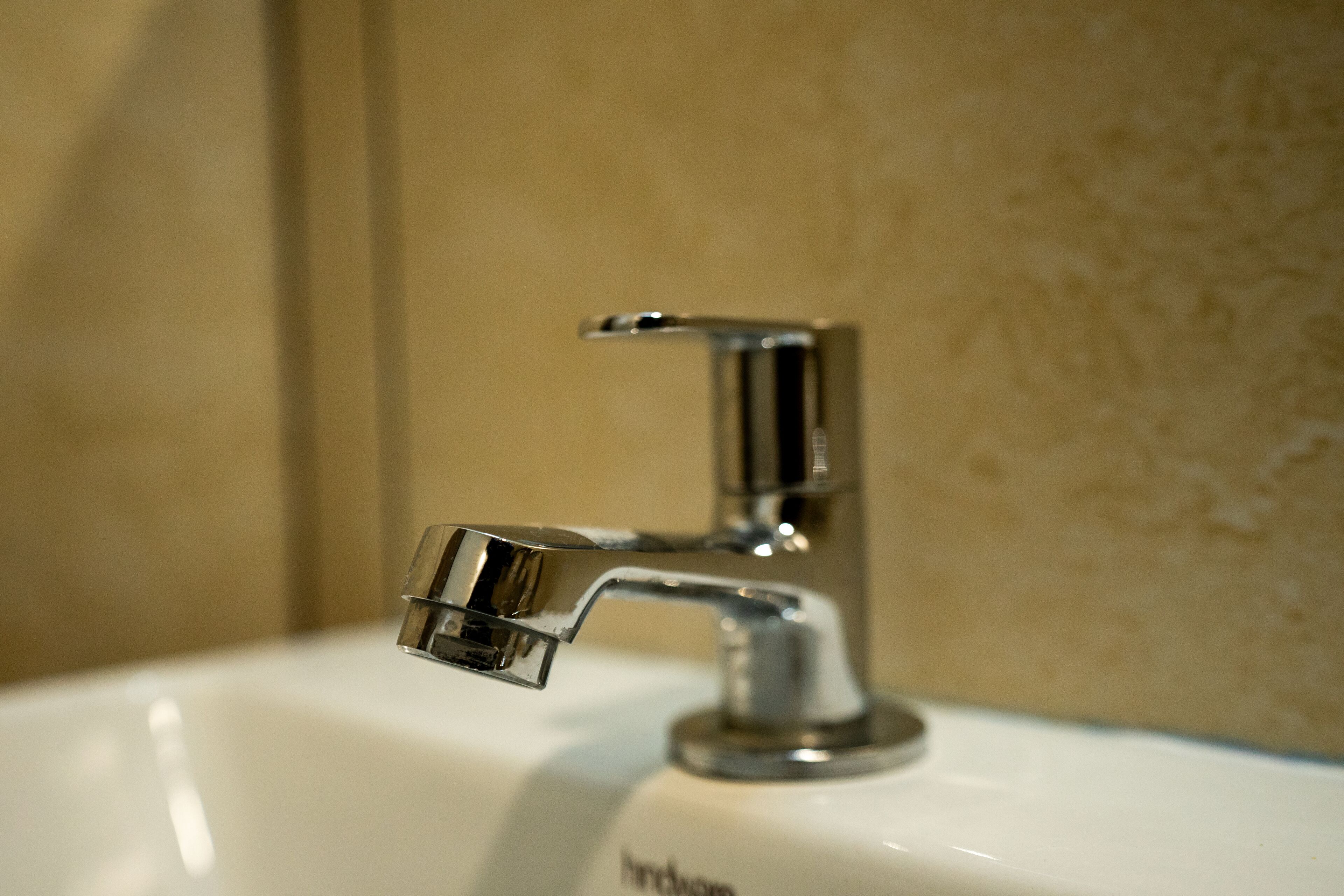 A bathroom sink with a chrome faucet and a visible brand name.