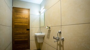 Een badkamer met een houten deur, een wastafel en een spiegel.