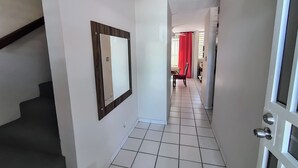 A hallway with a tiled floor, a wooden-framed mirror, and a door with a keyhole. - Ginger House. Charming 3-bedroom townhome, fast WiFi, A/C in enchanting Rincón (Rincón)