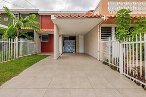 A residential property with a covered entrance, a tiled driveway, and a white fence. - Ginger House. Charming 3-bedroom townhome, fast WiFi, A/C in enchanting Rincón (Rincón)
