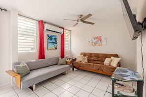 Ein Wohnzimmer mit einer Couch, einem Couchtisch und einem Deckenventilator.