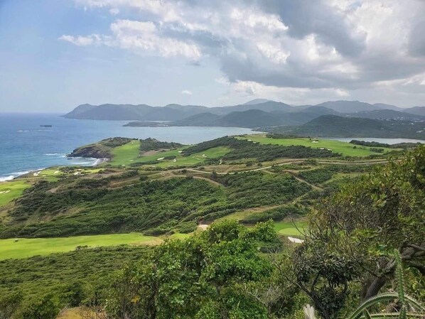 A coastal landscape with rolling hills, a golf course, and a view of the sea and distant mountains. - Villa Chilla 2 Villa (Gros Islet)