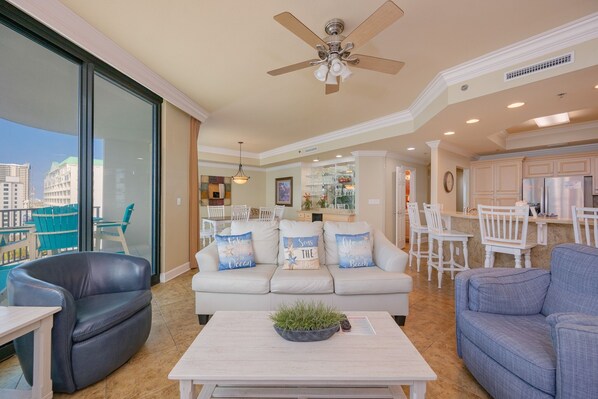 A spacious living area with a sofa, a coffee table, and a ceiling fan.