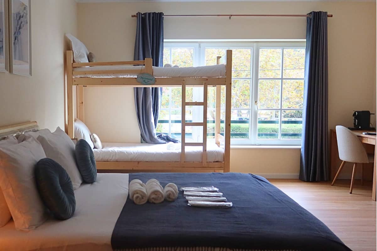 Een slaapkamer met een stapelbed, een bureau en een stoel.