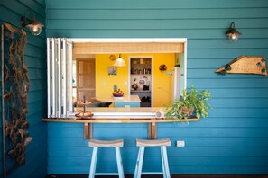 A kitchen with a yellow wall, a window, and a plant on the counter. - Casa Mariposa (Riordanvale)