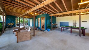 An indoor recreational area with a pool table, seating, and a covered patio. - Casa Mariposa (Riordanvale)