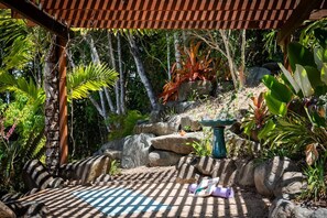 A garden with a pergola, rocks, and tropical plants. - Casa Mariposa—A Secluded Tropical Sanctuary (Riordanvale)