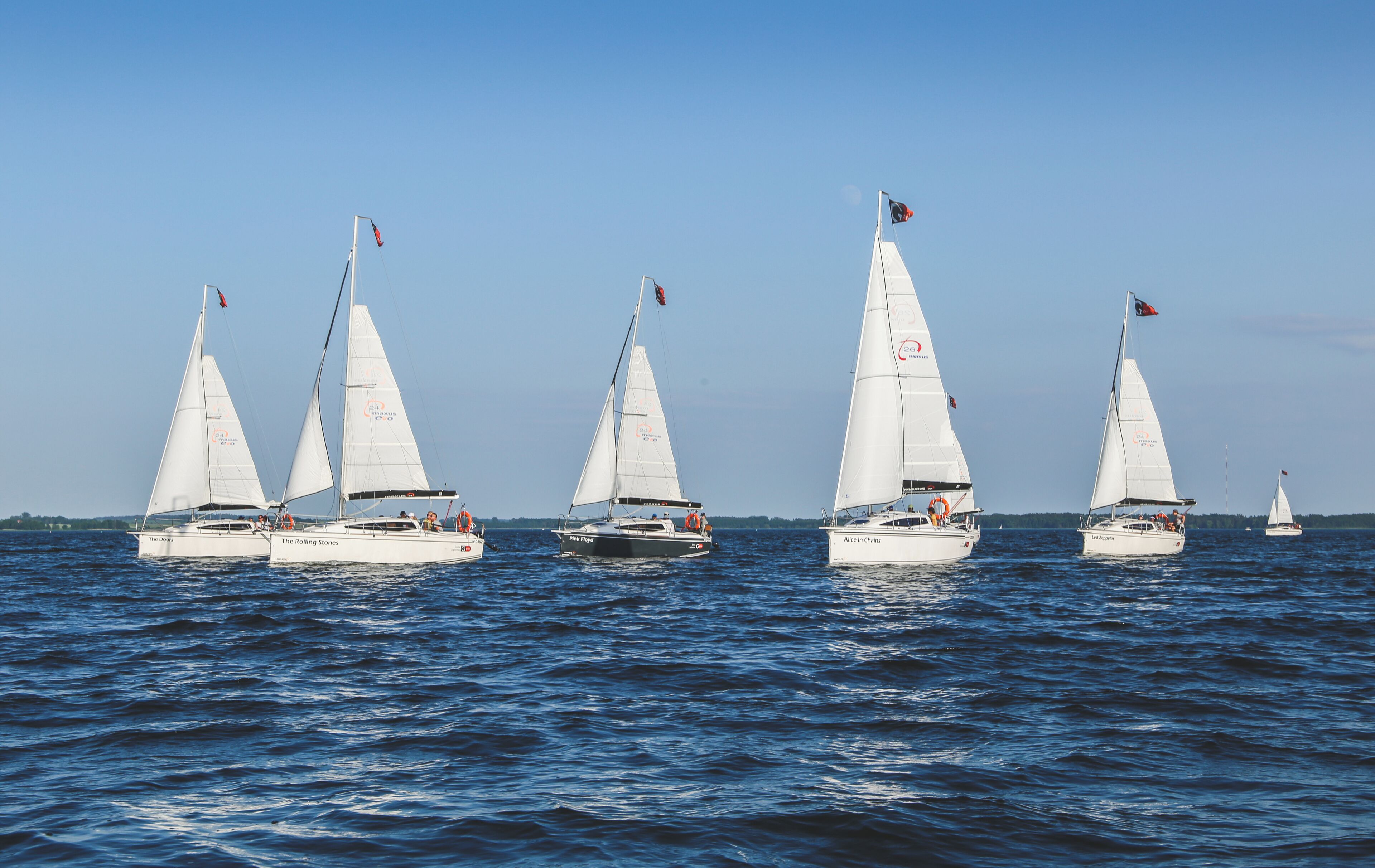 Eine Flotte von Segelbooten auf ruhigem Wasser.
