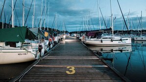 Een jachthaven met verschillende boten afgemeerd aan een houten steiger.