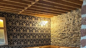 A cozy living room with a brown leather sofa, a stone coffee table, and a stone wall. - Le grand Second, charming gîte for 5 people near Spa town center. (Spa)