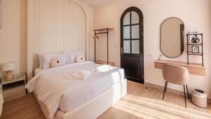 A bedroom with a bed, bedside table, lamp, and a mirror on the wall. - Oxygen Valley Khao Yai C8 (Pak Chong)
