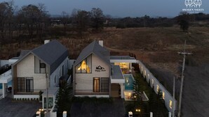 A modern two-story house with a swimming pool, a covered patio, and a well-maintained lawn. - Oxygen Valley Khao Yai C8 (Pak Chong)