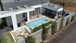 A modern two-story house with a swimming pool, outdoor seating, and a balcony. - Oxygen Valley Khao Yai C8 (Pak Chong)