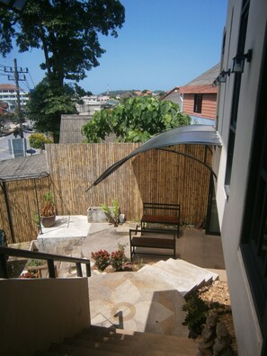 A patio with a bamboo fence, a bench, and a potted plant. - Infinity Boutique Hotel Kata Beach (Karon)