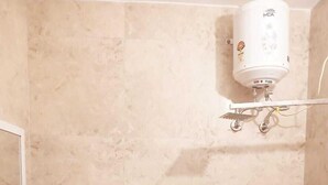 Une salle de bain avec un lavabo blanc, des toilettes et un radiateur fixé au mur.