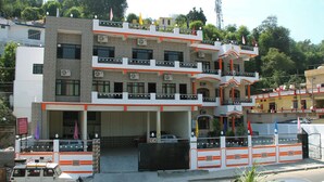Ein mehrstöckiges Hotel mit Balkonen, Klimaanlagen und einem verschlossenen Eingang.