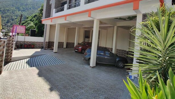 Ein Hotel mit überdachtem Parkplatz, mehreren Stockwerken und Bergblick.