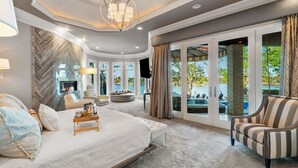 Un dormitorio moderno con una cama grande, zona de estar y vistas al exterior.