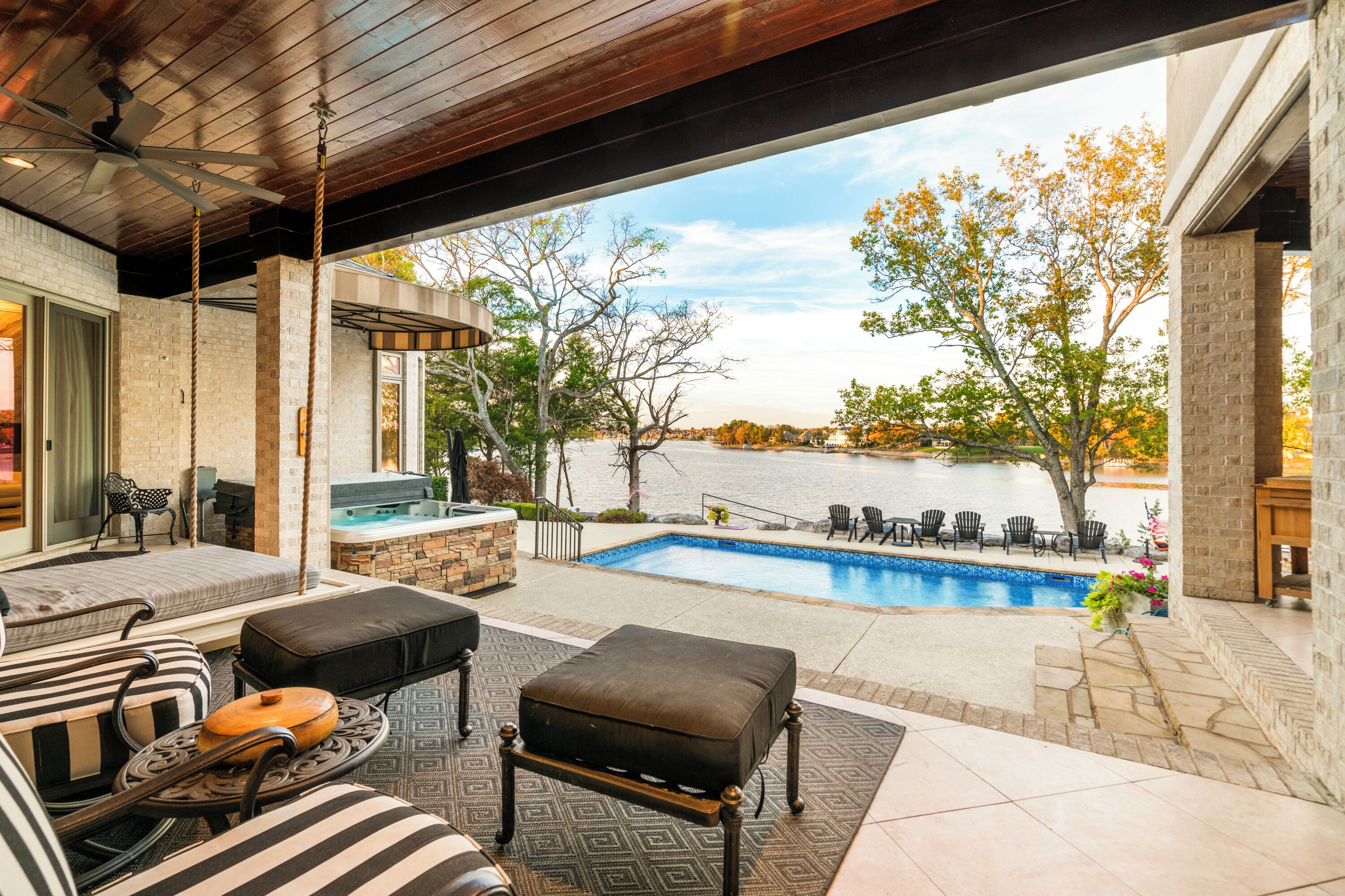 Une terrasse extérieure avec une piscine, des sièges et un jacuzzi.