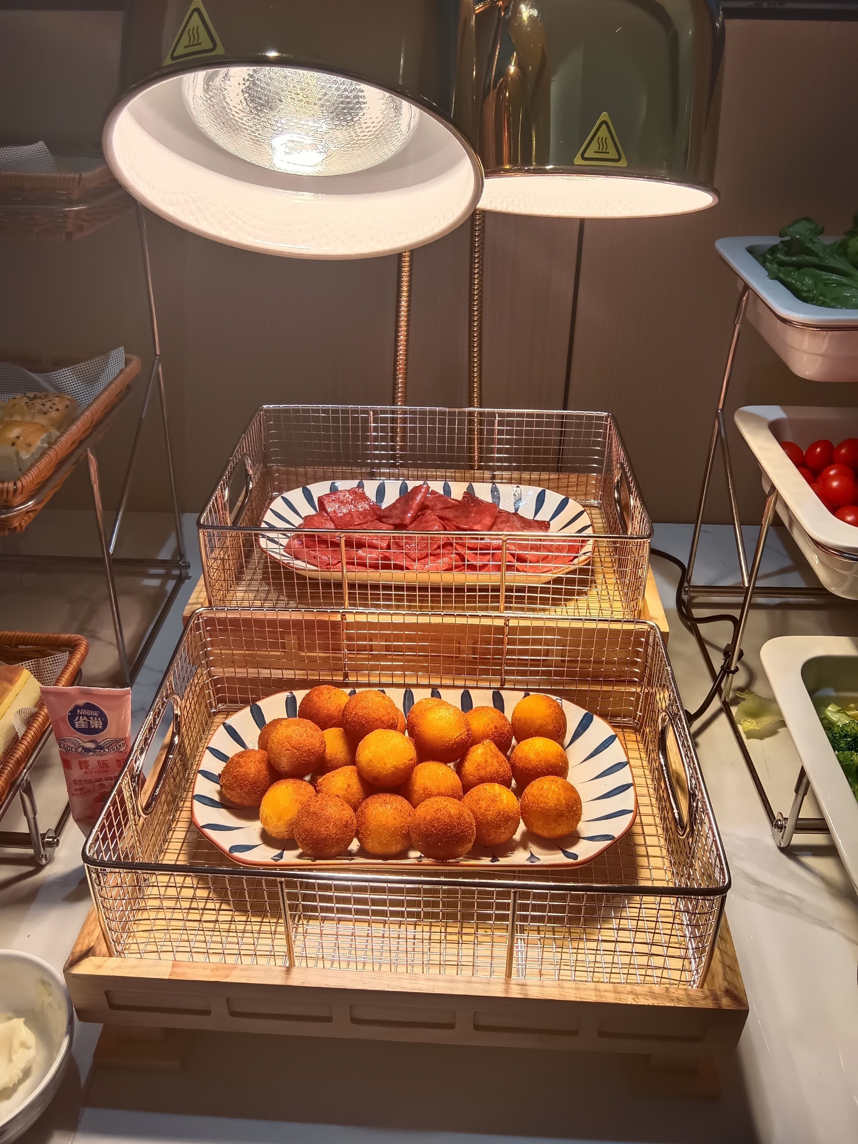 Una mesa de buffet con diversos alimentos, como pan, carne y una fuente de comida frita.