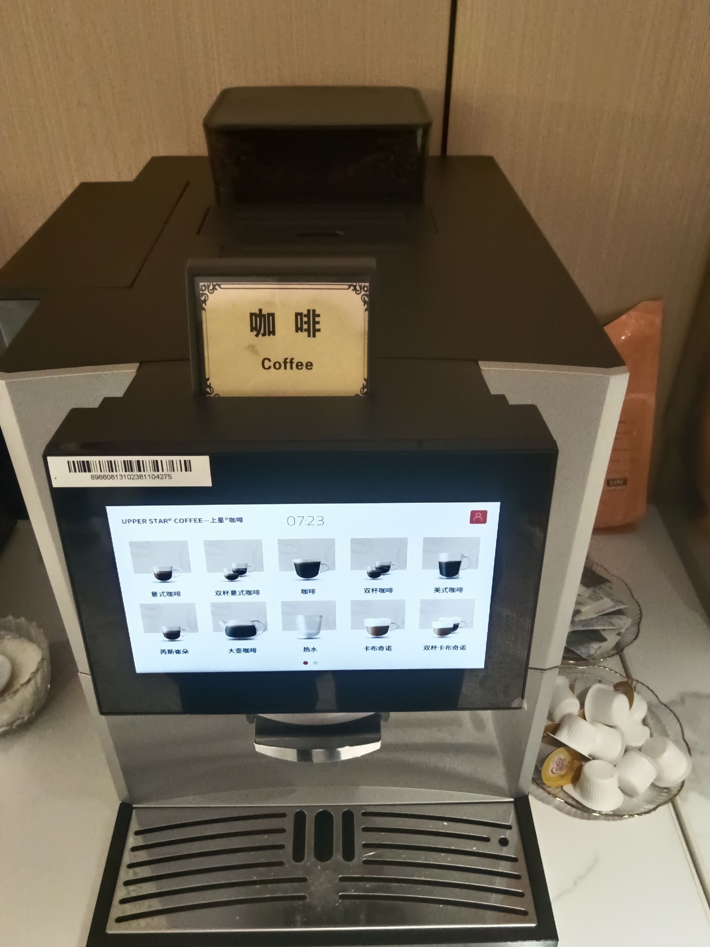 Una máquina de café con pantalla digital y un letrero que indica que sirve café.