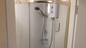 Eine Duschkabine mit einer Handbrause und einem zusätzlichen Duscharm.