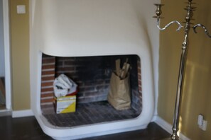 Eine Ecke eines Raumes mit Kamin, weißer Wand und einem Messing-Leuchter.