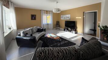 A living room with a sofa, a television, and a coffee table.