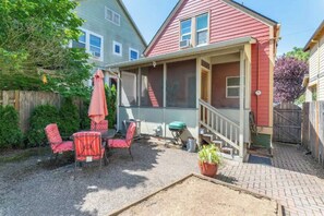 A backyard with a covered patio, outdoor seating, a grill, and a potted plant. - Charming 3bed Home w/ Yard - Walk Score 91! (Portland)