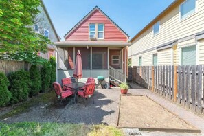 A red house with a porch, a table with chairs, and a potted plant. - Charming 3bed Home w/ Yard - Walk Score 91! (Portland)