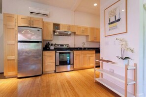 A modern kitchen with wooden cabinets, stainless steel appliances, and a white countertop. - ON Alberta Street: Private Loft w/ Rooftop! (Portland)