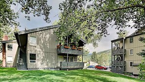 A two-story building with a balcony, a staircase, and a car parked in the driveway. - Local`s Condo in Vail, Steps from Ski Shuttle (Vail)