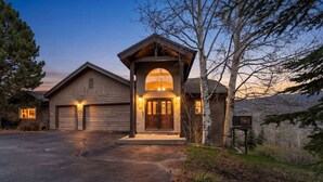 A two-story building with a garage, a covered entrance, and a driveway. - Gold Dust Getaway | Hot tub | Near Ski Resorts (Edwards)