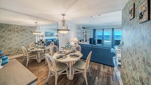A dining area with a round table, chairs, and hanging light fixtures.