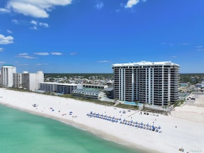 A beachfront hotel with multiple high-rise buildings, a sandy beach, and a pool area. - FREE Golf & Perks! Mariner West 504 Beachfront Swimming Pool, Tennis & Grill! (Panama City Beach)