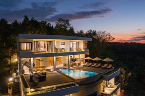 A modern two-story house with a swimming pool, outdoor seating, and a balcony. - Villa Kalliste (Penida Island)
