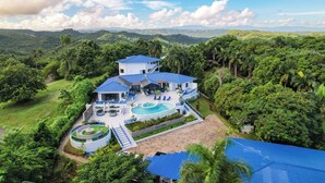 A large house with a pool, surrounded by lush greenery and hills. - 13 bedroom Ultimate Private Luxury Compound  with every amenity you can imagine (Sosúa)