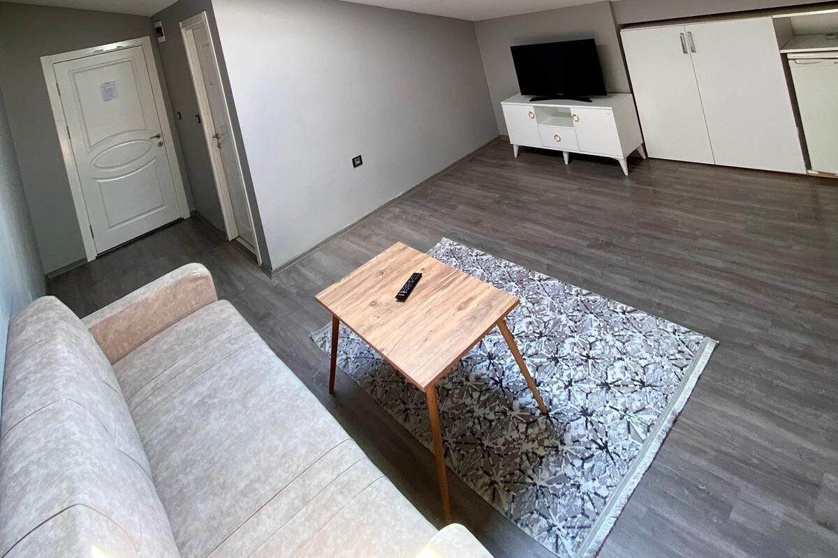 A modern living room with a sofa, a coffee table, a TV, and a wardrobe.