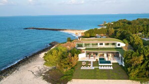 Une propriété située sur la côte, dotée d’une grande piscine, d’un espace extérieur aménagé et offrant une vue sur la mer.