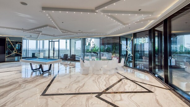 A spacious indoor area with a pool table, seating, and large windows offering views of the city. - Capacious 3BR Apartment in Bayz Tower, Business Bay by Deluxe Holiday Homes (Dubai)