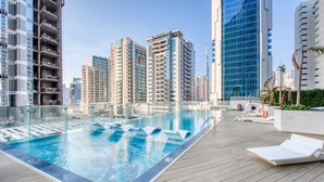 A rooftop pool with clear blue water, surrounded by modern high-rise buildings. - Capacious 3BR Apartment in Bayz Tower, Business Bay by Deluxe Holiday Homes (Dubai)