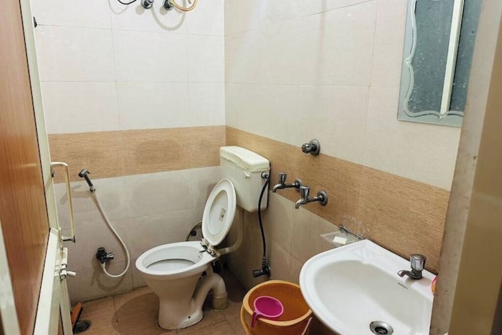 Une petite salle de bain avec des toilettes, un lavabo et une douche.