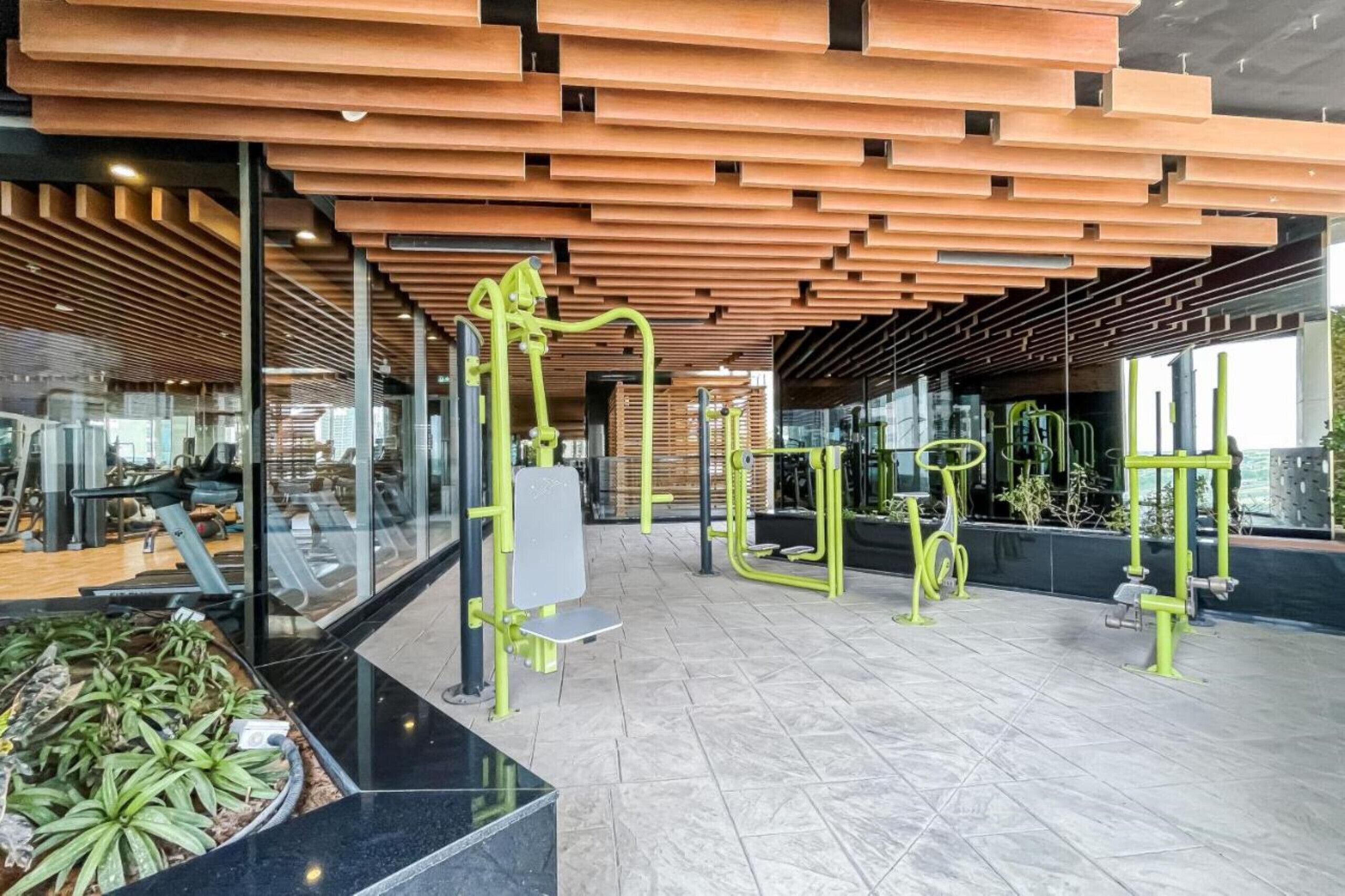 A modern gym with exercise equipment and a wooden ceiling.