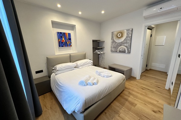Bedroom with double bed, mirror, console table and open closet