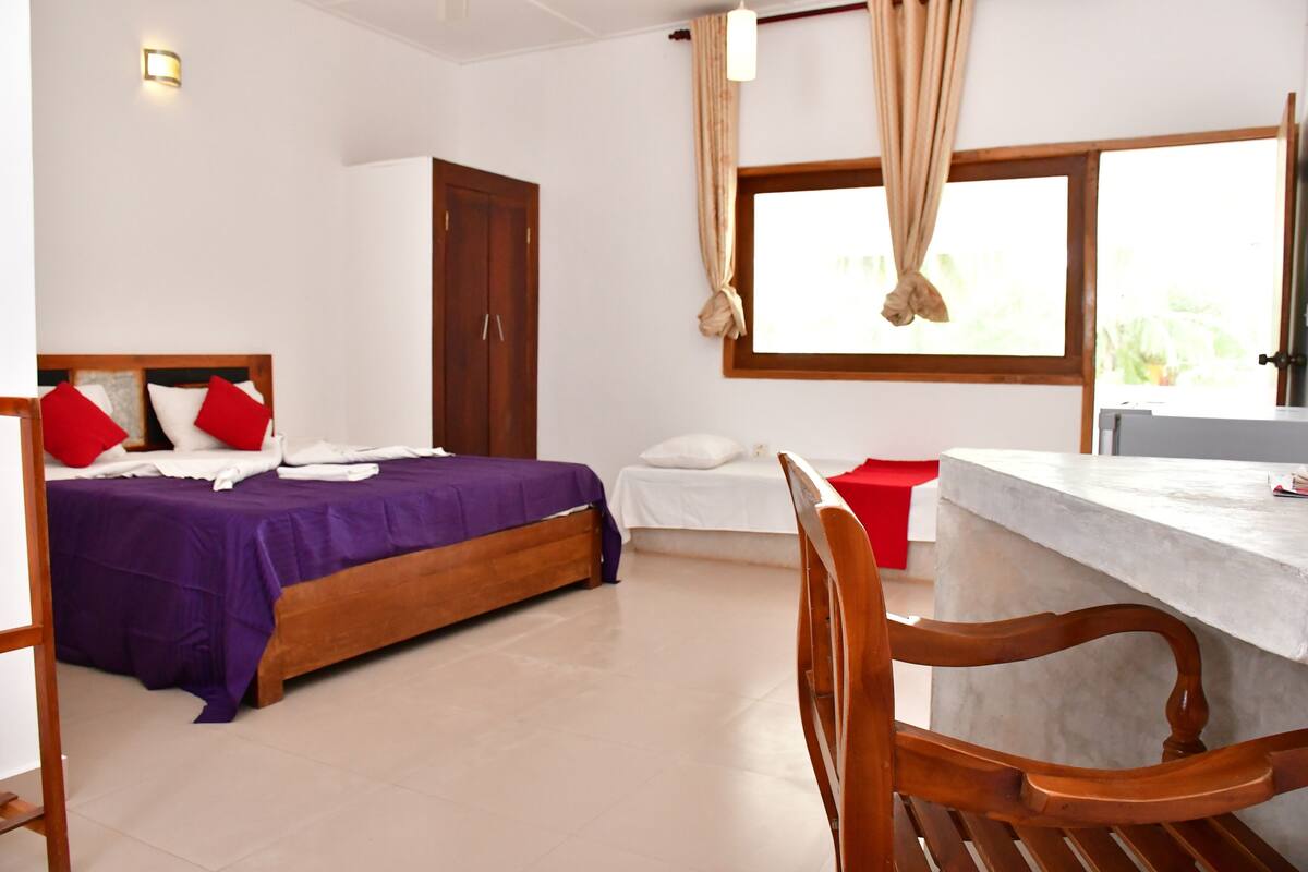 A hotel room with a bed, a desk, and a chair.