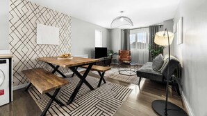 Un salon moderne comprenant une table à manger, un banc, un canapé et une lampe sur pied.